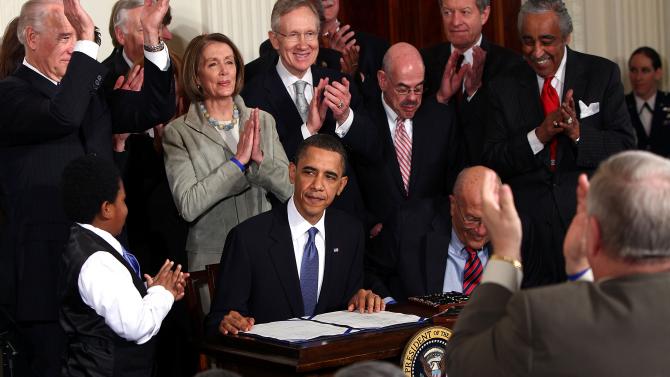 97969576-president-barack-obama-is-applauded-after-signing-the
