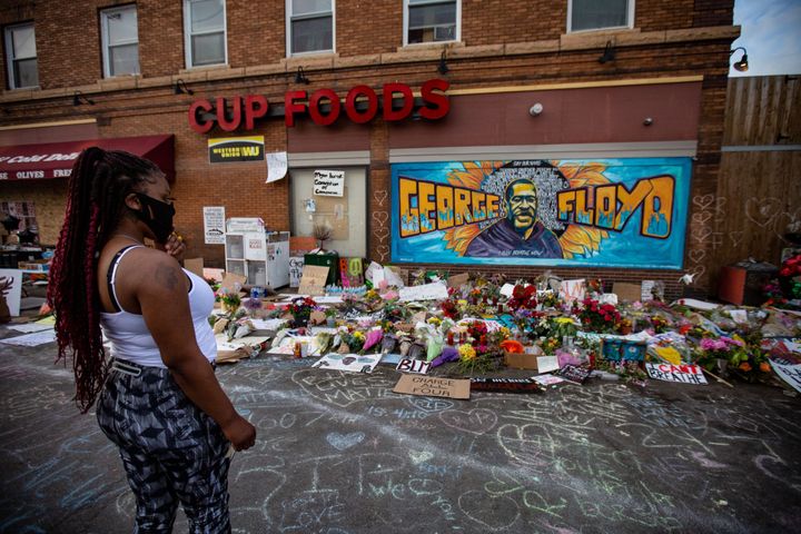 A woman pays her respects at the makeshift memorial and mural outside Cup Foods in Minneapolis on May 31.