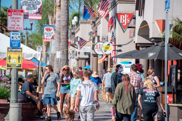 Beachgoers, many maskless, walk down Main Street in Huntington Beach, California. Residents of the city south of Los Angeles have been notably&nbsp;<a href="https://www.latimes.com/socal/daily-pilot/news/story/2020-06-30/huntington-beach-restaurants-no-mask-position-deeply-divides-o-c-diners" target="_blank" rel="noopener noreferrer" data-ylk="subsec:paragraph;itc:0;cpos:1;pos:3;elm:context_link" data-rapid_p="3" data-v9y="1">anti-mask</a>&nbsp;and <a href="https://timesofsandiego.com/politics/2020/05/01/thousands-many-without-masks-protest-lockdown-in-huntington-beach/" target="_blank" rel="noopener noreferrer" data-ylk="subsec:paragraph;itc:0;cpos:1;pos:4;elm:context_link" data-rapid_p="4" data-v9y="1">lockdown-averse,</a>&nbsp;in spite of rising coronavirus cases in the region.